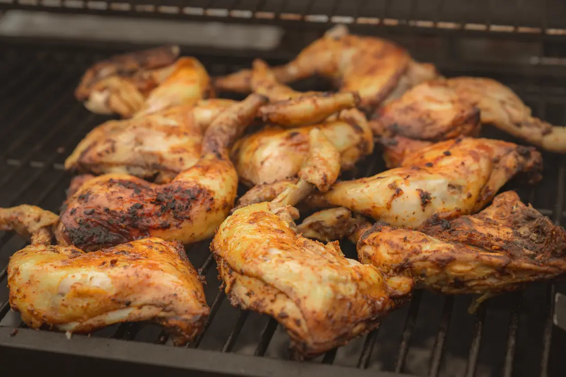Chicken pieces cooking on the grill
