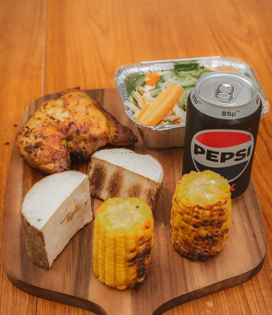 Chicken meal with yam, roasted corn, salad, and Pepsi