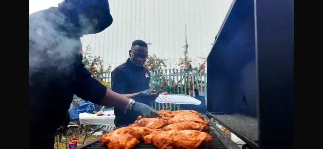 Outdoor catering team grilling marinated chicken