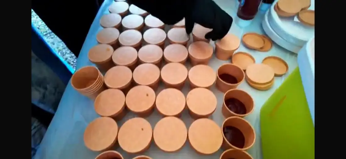 Sauce cups being prepared for catering